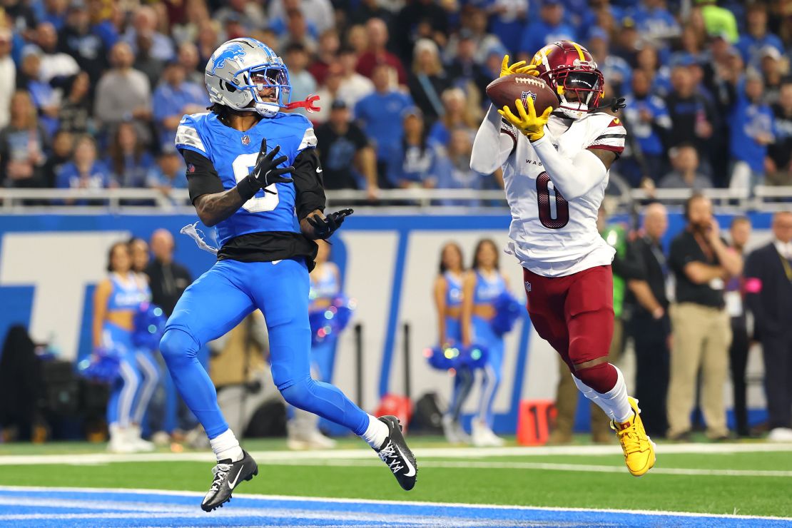 Mike Sainristil #0 of the Washington Commanders intercepts a pass intended for Jameson Williams #9 of the Detroit Lions during the second quarter in the NFC Divisional Playoff.