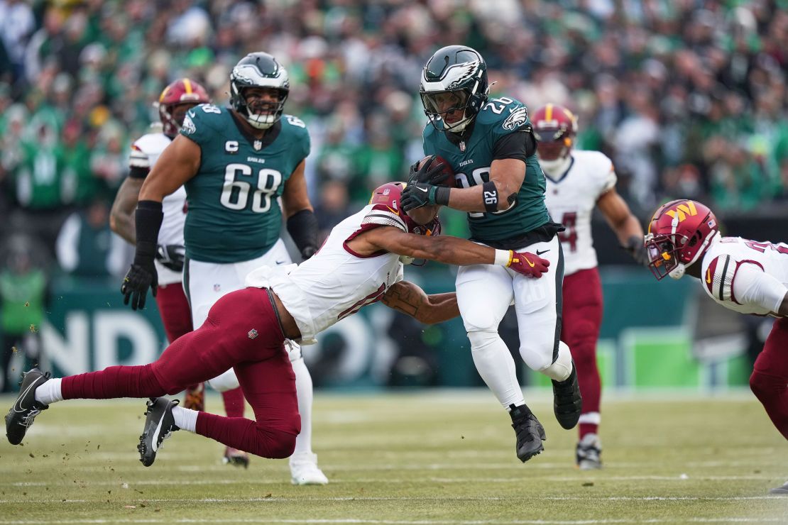 Philadelphia Eagles running back Saquon Barkley (No. 26) breaks away from Washington Commanders safety Jeremy Chinn (No. 11) to score a touchdown.