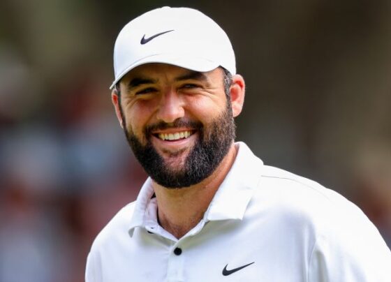 Scheffler and caddie Ted Scott celebrate on the 18th green after winning the Masters.