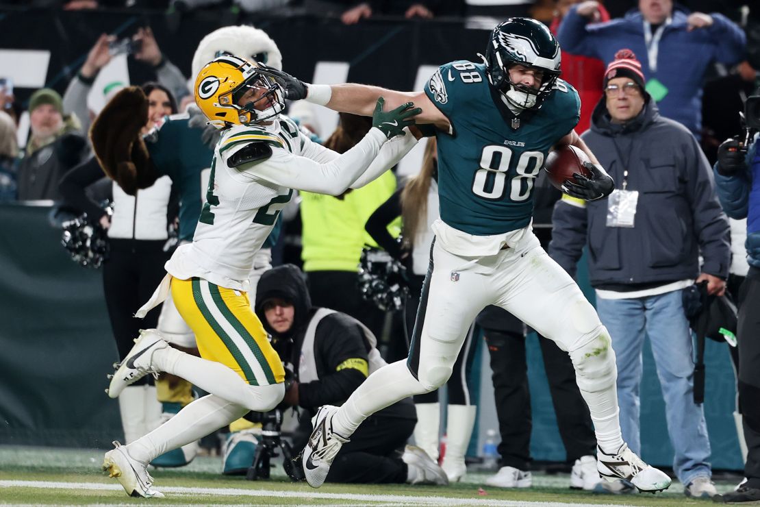 Dallas Goedert of the Philadelphia Eagles stiff arms Carrington Valentine of the Green Bay Packers before scoring a third quarter touchdown during the NFC Wild Card Playoff.