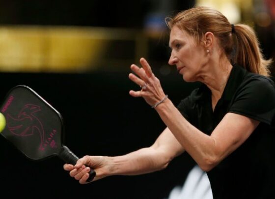 Graf returns a volley from John McEnroe as teammate Andre Agassi looks on during Pickleball Slam 2.