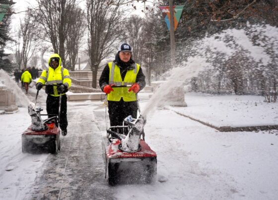 Workers clear snow.