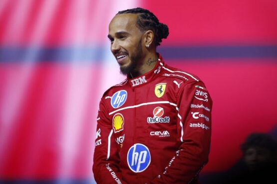 Hamilton walks out on stage with the new Ferrari car, alongside team principal Frédéric Vasseur and driver Charles Leclerc.