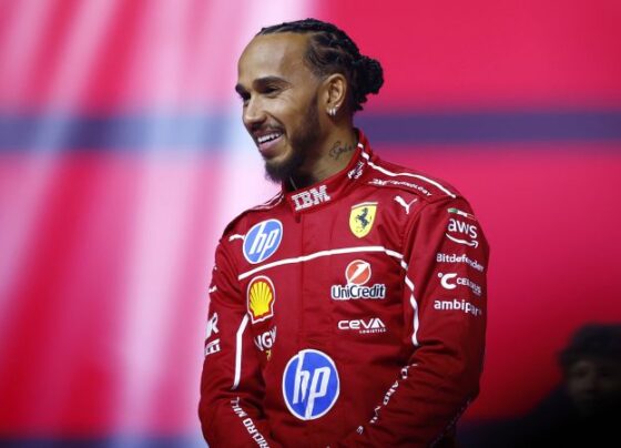 Hamilton walks out on stage with the new Ferrari car, alongside team principal Frédéric Vasseur and driver Charles Leclerc.