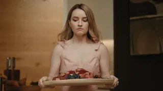 Kaitlyn Dever holding a plate of fruit in Apple Cider Vinegar